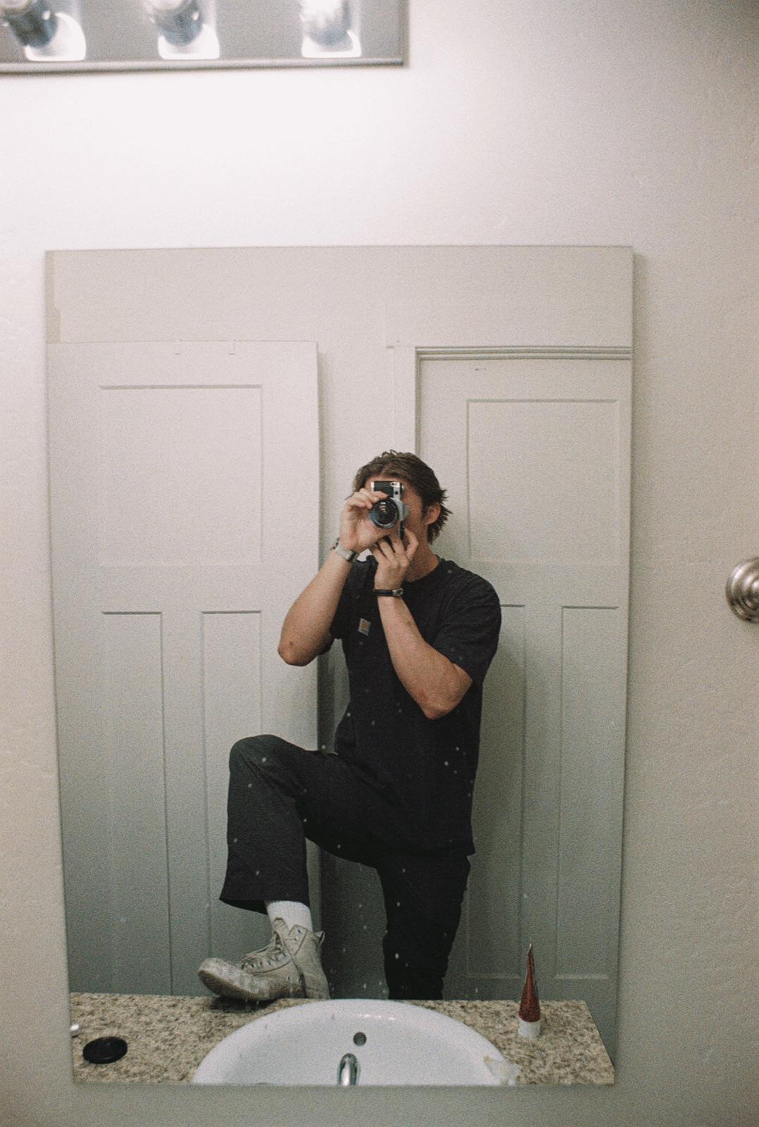 Boston taking a mirror self-portrait with a film camera