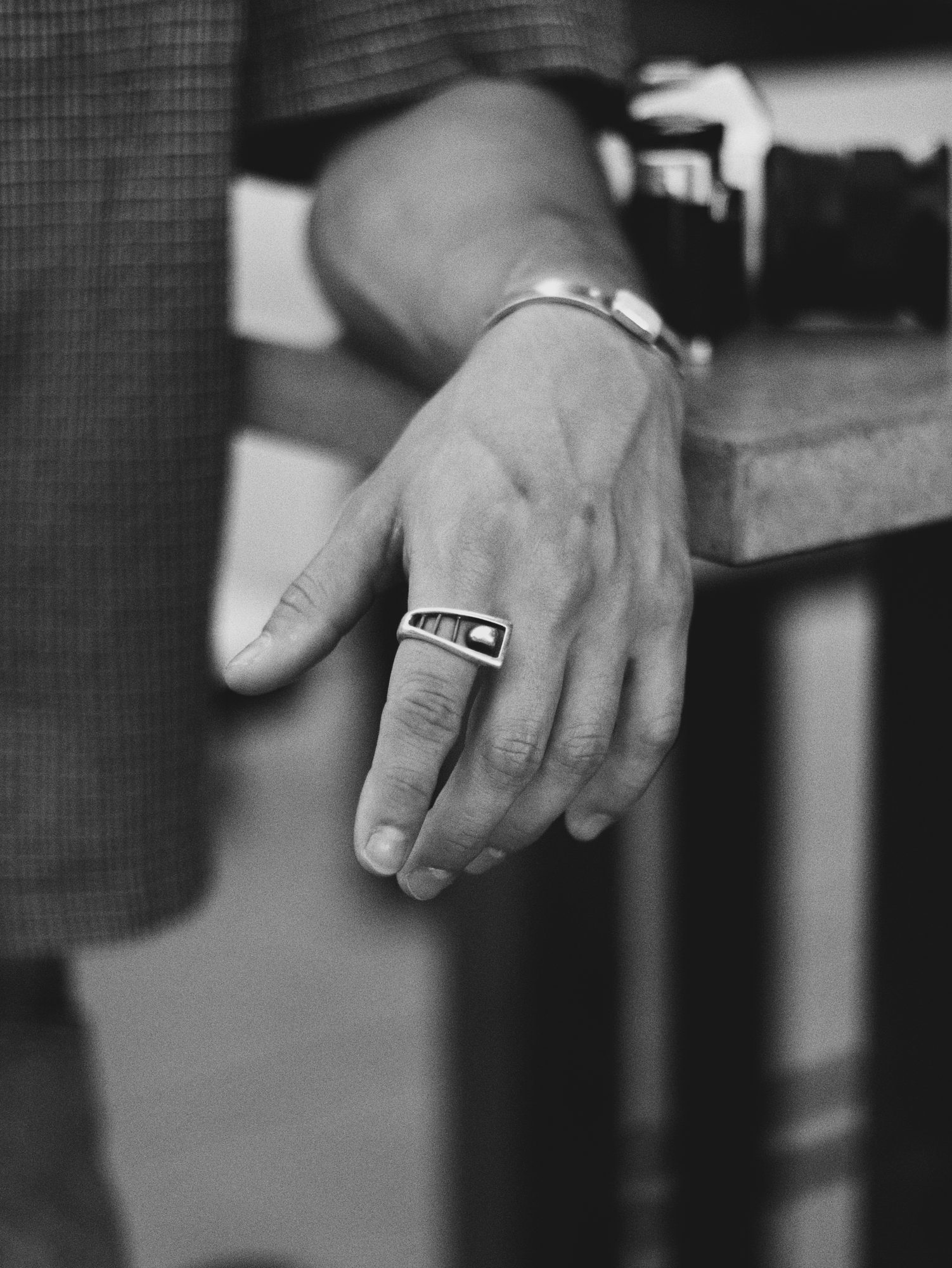 Close-up of a silver ring and cuff on Boston's hand